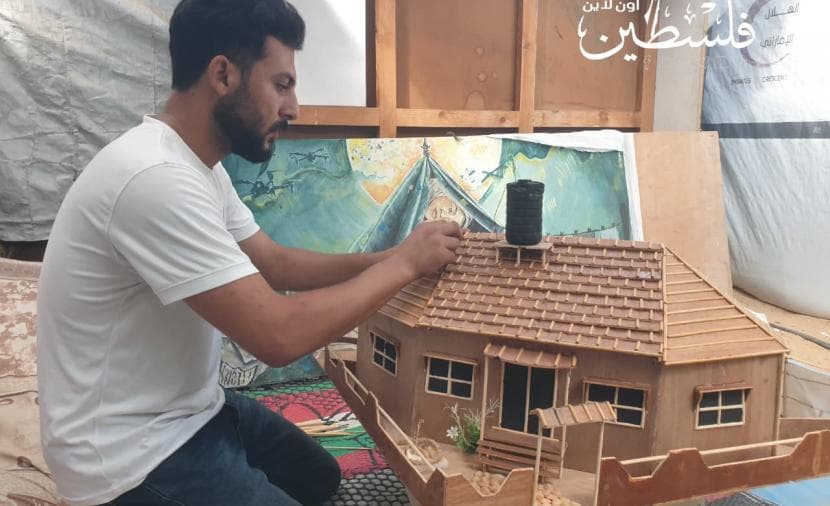 فنان غزي يعيد بناء منزله وسط التهجير