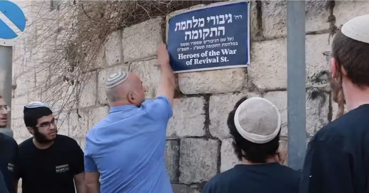مستوطنون يغطون لافتة صلاح الدين في القدس