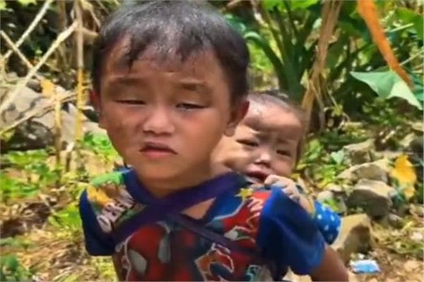 Child carries sister through Nepal rubble