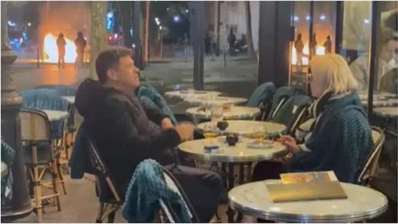 Couple relaxes at Paris café amid protests