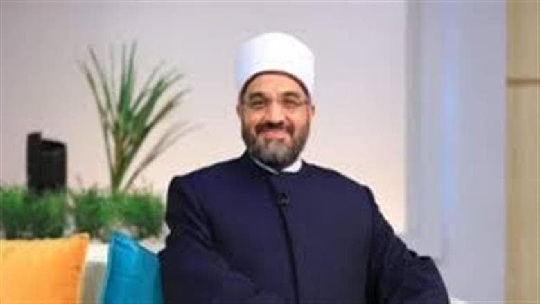 Standing behind seated Imam ruling