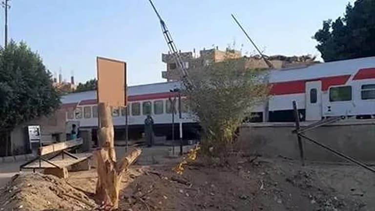 Train passes open crossing in Qena