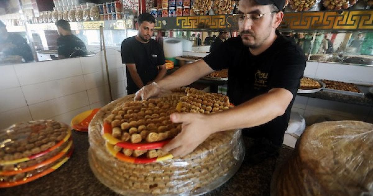 عمال يجهزون حلويات في غزة قبيل نتائج التوجيهي