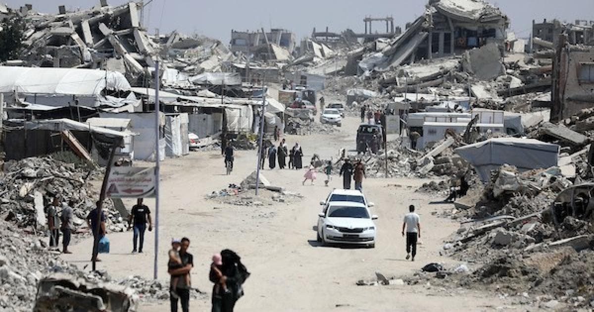 فلسطينيون يمشون في مخيم جباليا