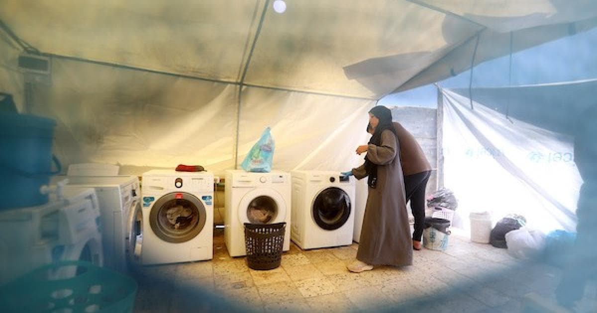 فلسطينيون يغسلون ملابسهم في مخيم غزة