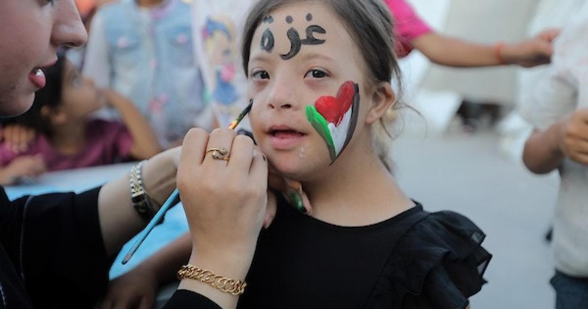 Palestinian children watch outdoor film in Gaza refugee camp