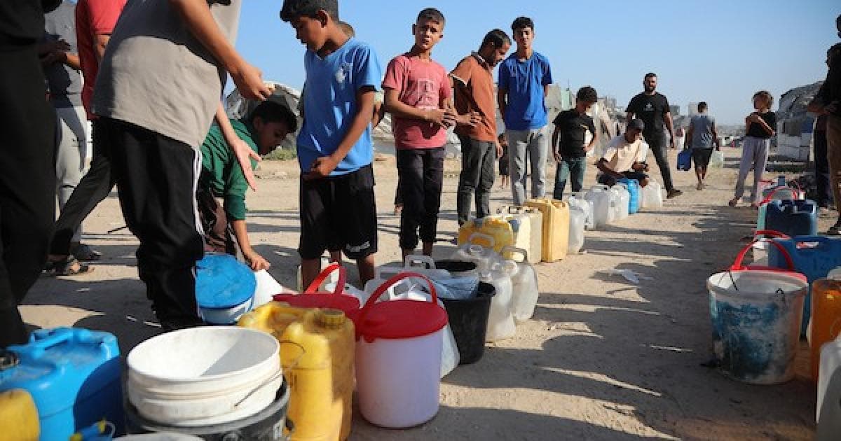 Children and families queue for water in Al-Nuseirat