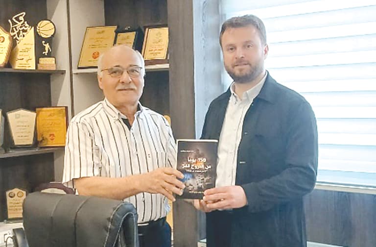Badr al-Din hands Ali Hasan his book on displacement