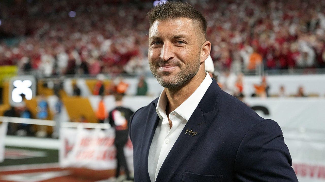 Someone brings a fitting item for Florida Gators legend Tim Tebow to autograph